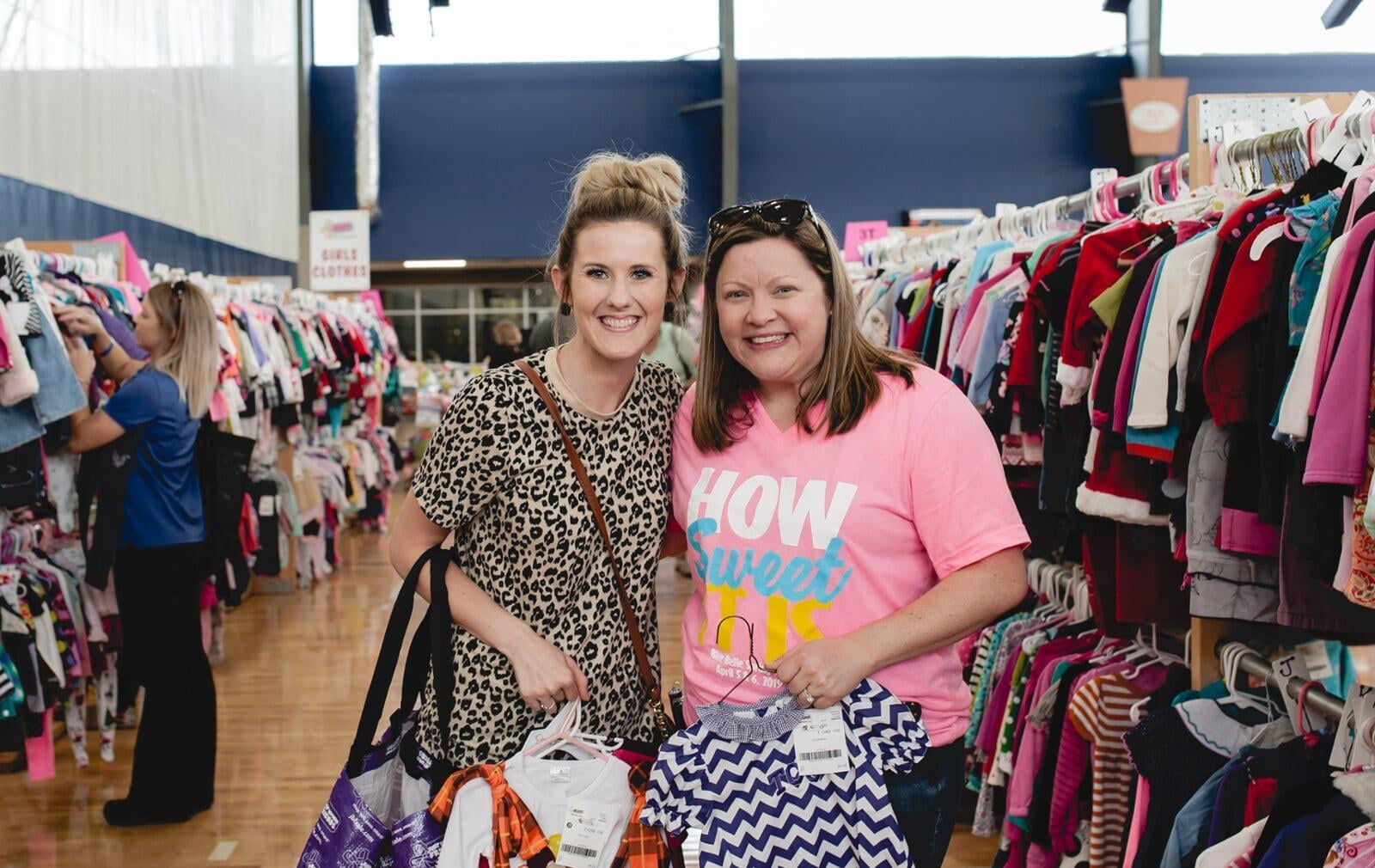 A mother and daughter stand side by side in their masks as they shop their local JBF sale.